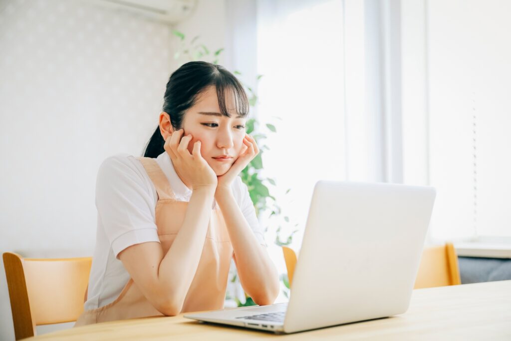 パソコンを見て悩む女性